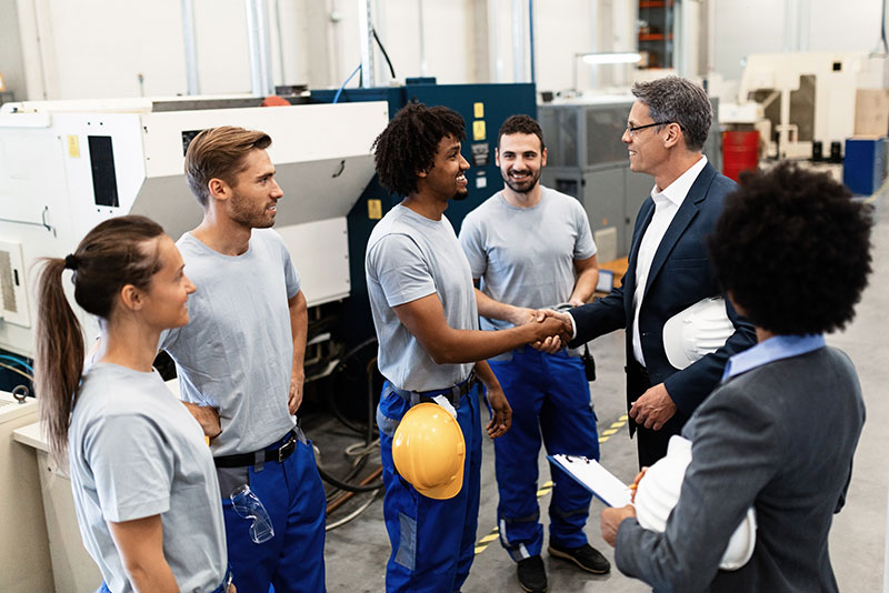 Cross-functional manufacturing team reviewing machine setup